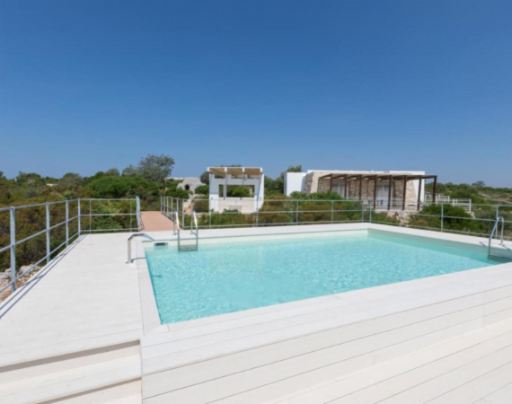 Buitenzwembad met witte houten vloer Fani Luxury Villas in Italië.