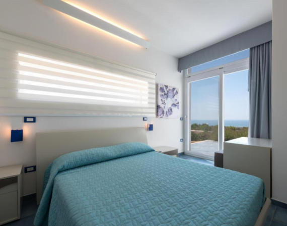 Kamer met een tweepersoonsbed en uitzicht op de zee Fani Luxury Villas in Italië.