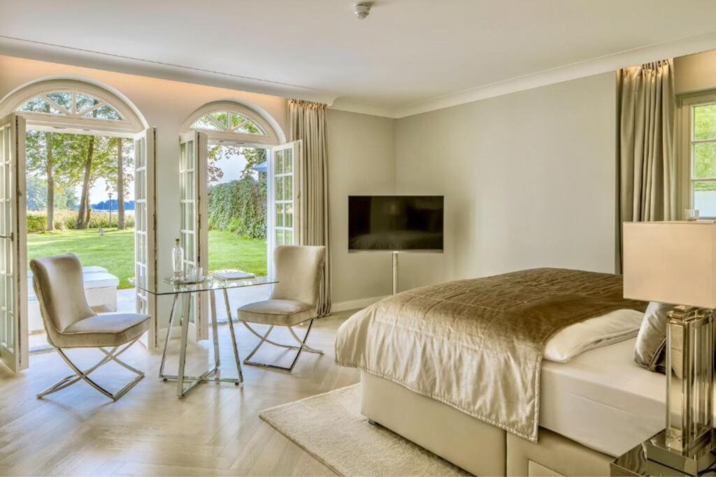Kamer met een tweepersoonsbed, een televisie en deuren naar het terras Villa Contessa in Duitsland.