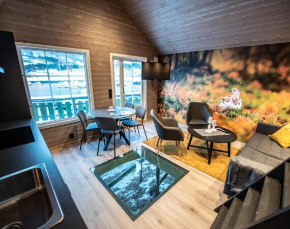 Manndalen Sjøbuer in Lapland Noorwegen woonkamer en keuken met raam in de vloer.