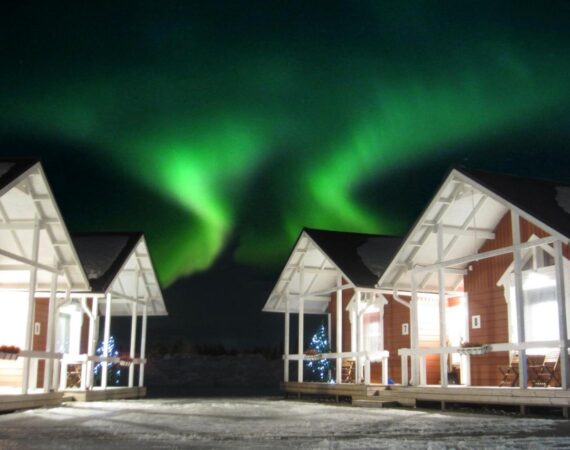 Santa Claus Holiday Village in Lapland Finland Vakantiehuisjes met het noorderlicht op de achtergrond.