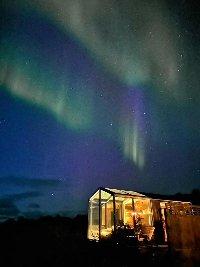Wonderinn Arctic in Lapland Noorwegen vakantie huisje in de natuur met noorderlicht op de achtergrond.