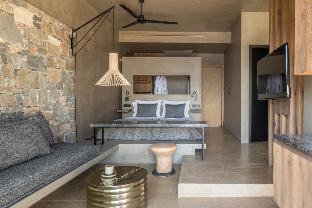 Acro Suites in Griekenland suite met een tweepersoonsbed, bank en televisie.