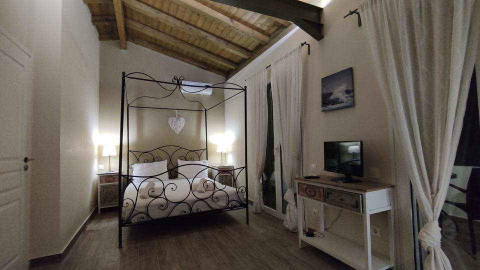 Adipni Villas in Griekenland slaapkamer met een tweepersoonsbed en een televisie.