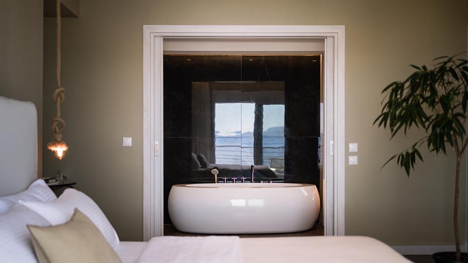 Kappa Luxury Villas & Suites Griekenland slaapkamer met bad erin Kappa Luxury Villas & Suites in Griekenland slaapkamer met een bad.