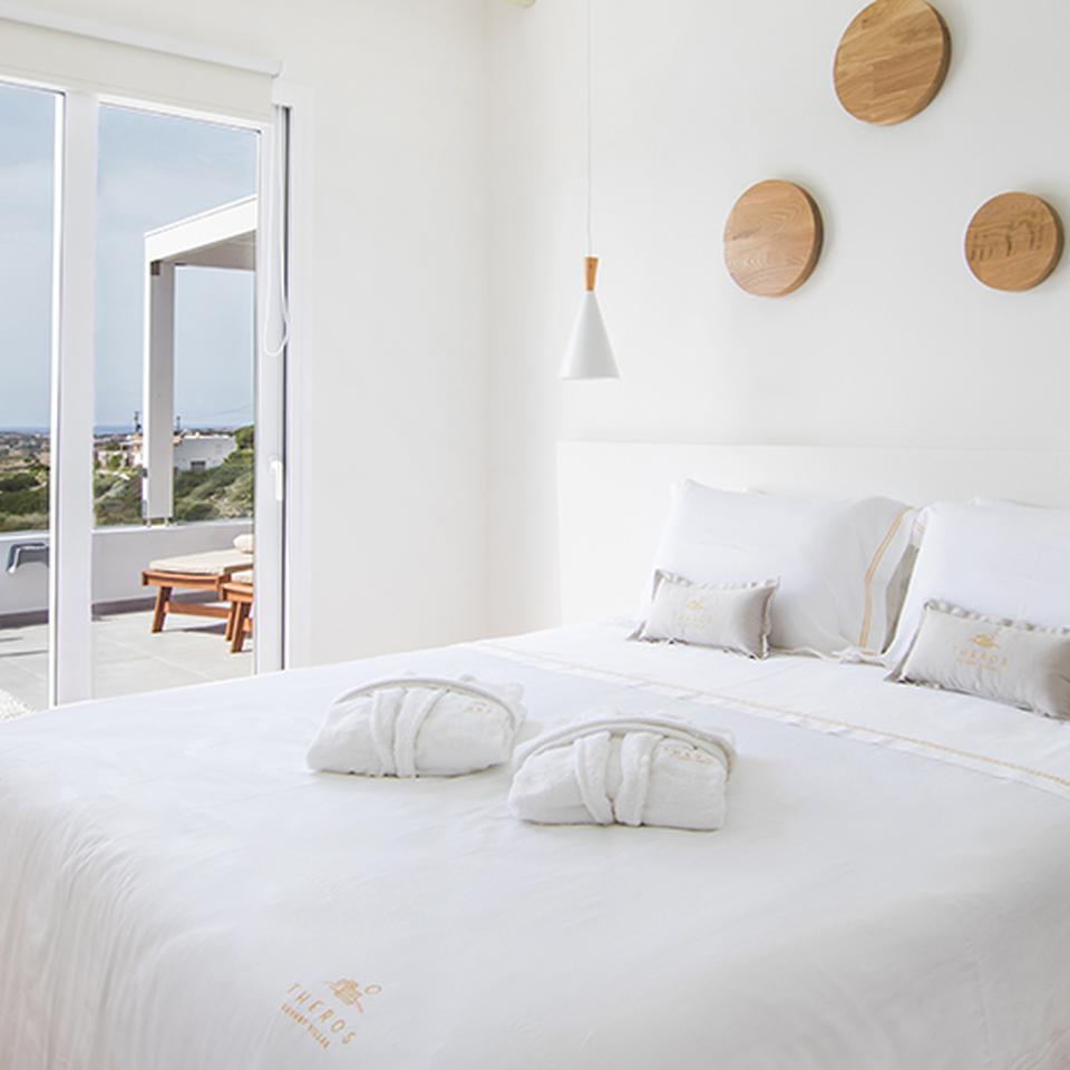 Theros Luxury Villas in Griekenland slaapkamer met een tweepersoonsbed.