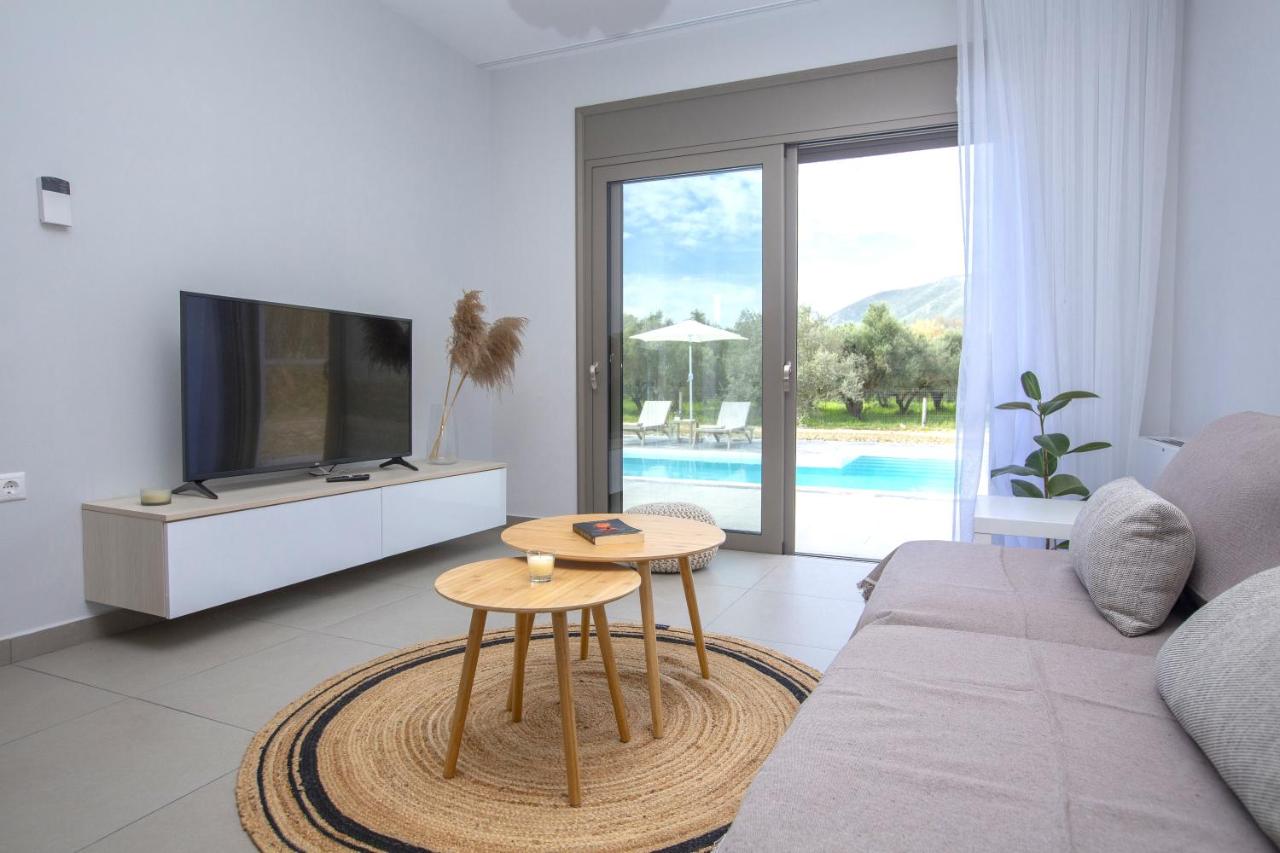 Throisma Private Country Residences Griekenland Woonkamer met tv Throisma Private Country Residences in Griekenland woonkamer met televisie en deuren naar buiten.