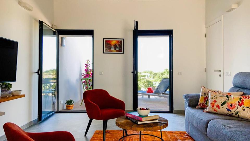 B&B Alma do Campo 2 Woonkamer met een televisie en twee deuren naar buiten in Faro Portugal.