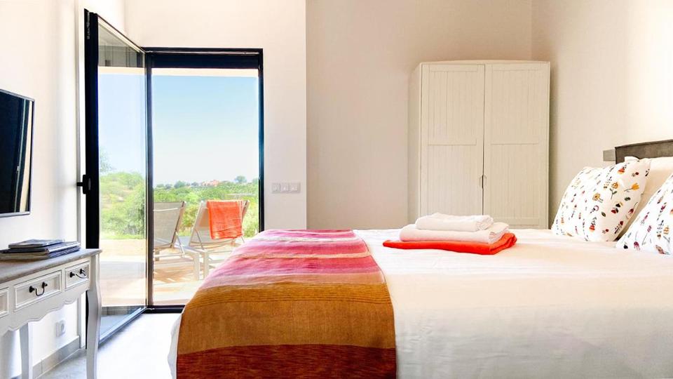 B&B Alma do Campo 3 Kamer met een tweepersoonsbed en een televisie en een deur naar buiten in Faro Portugal.