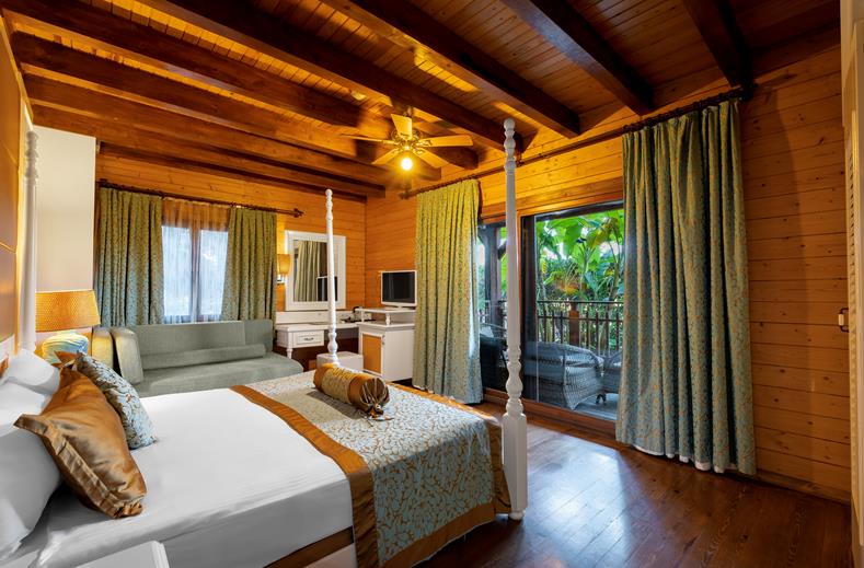 Kamer met een tweepersoonsbed, bank, televisie en een balkon Long Beach Alanya in Turkije.