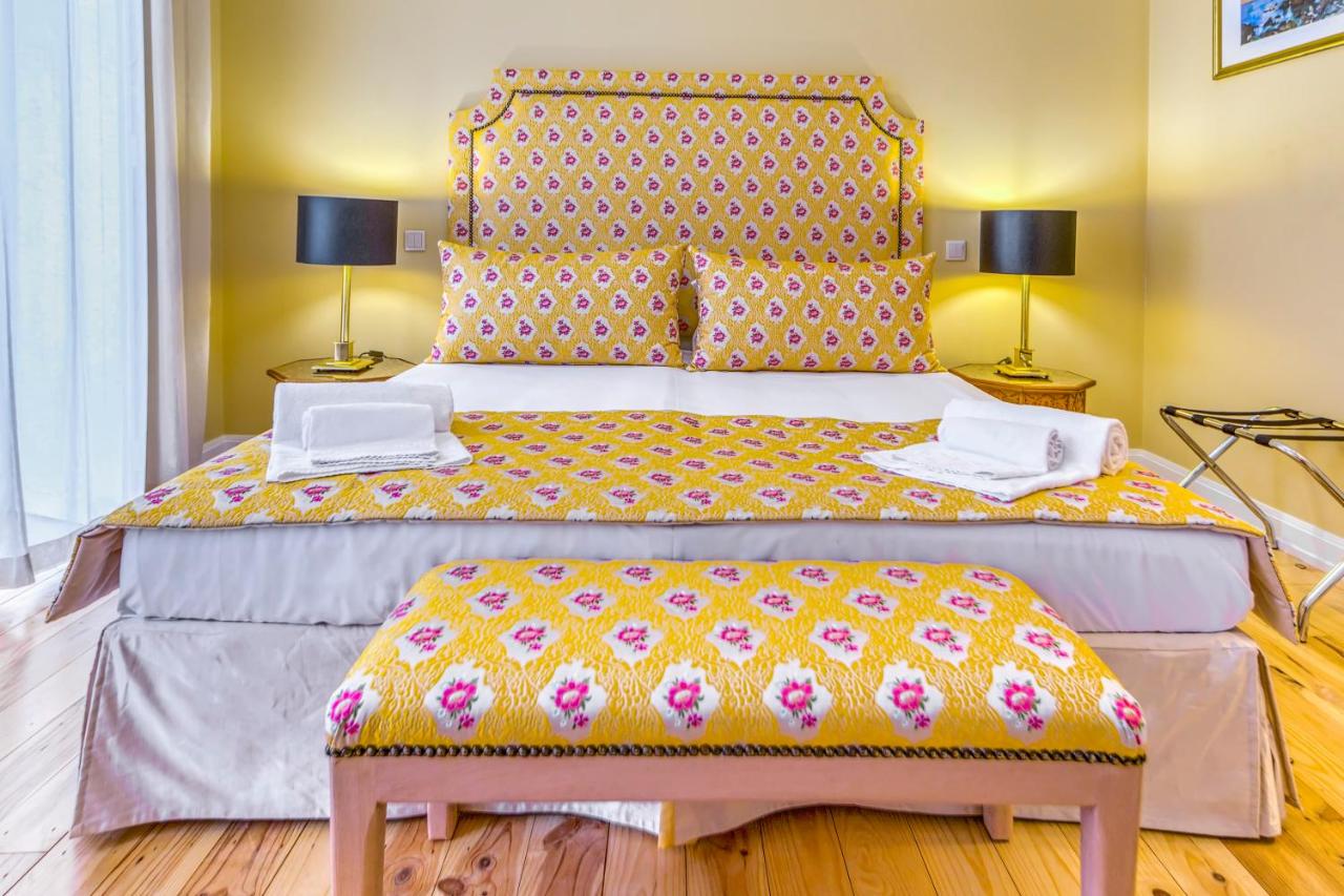 Mosaiko 5 Suites 5 Geel gekleurde hotelkamer met een tweepersoonsbed in Faro Portugal.