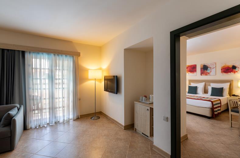 Familiesuite met een woonkamer met televisie Paloma Grida in Turkije.
