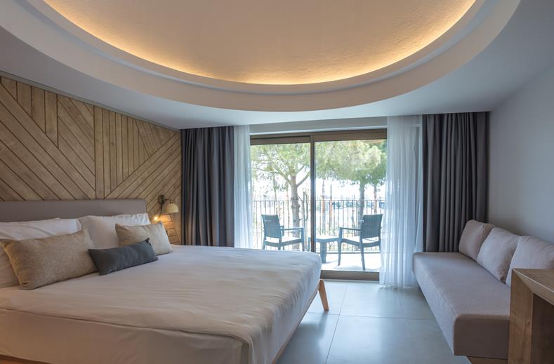 Kamer met een tweepersoonsbed, een bank en een balkon Paloma Orenda in Turkije.