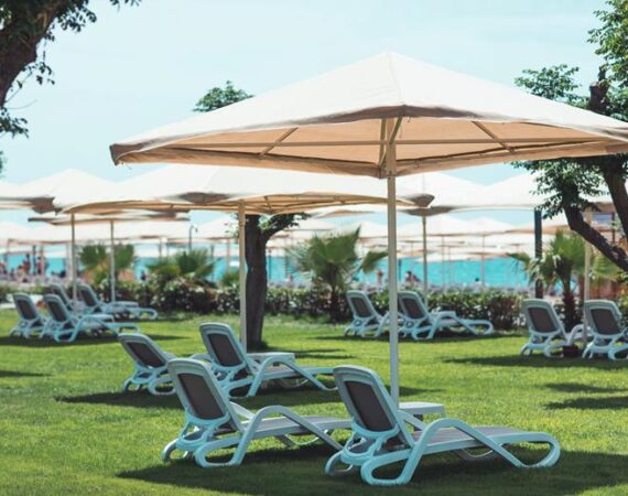 Ligbedden op het gras met parasols Paloma Orenda in Turkije.